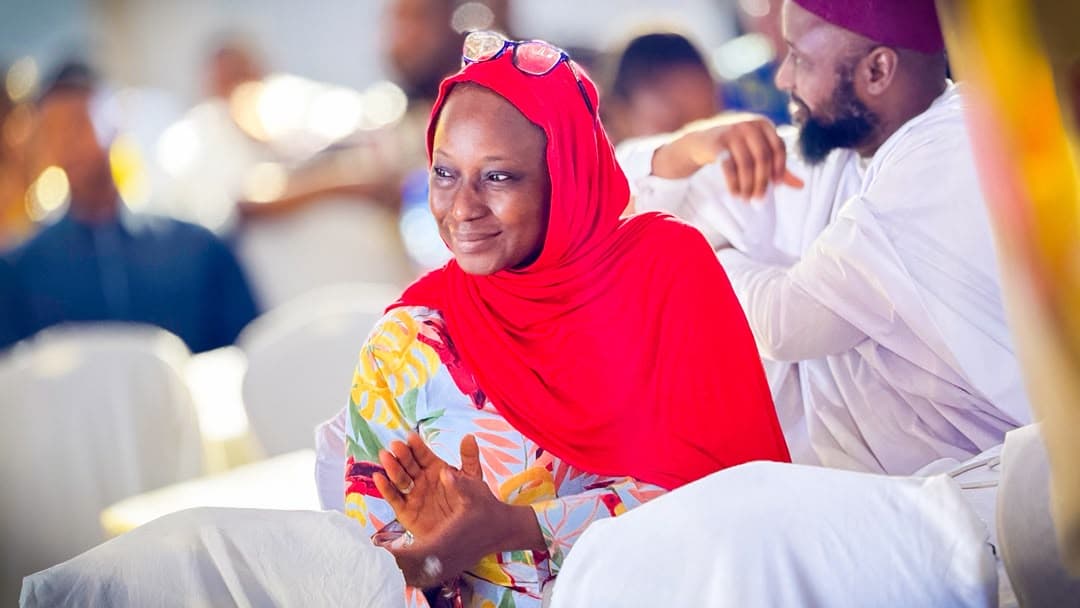 A member in a red hijab listening at a Valiant gathering